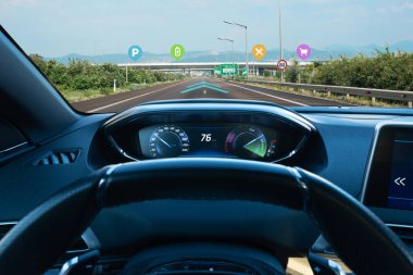 Gelecekçi akıllı araba konsepti EV şarj cihazlarını, park noktalarını, alışveriş seçeneklerini ve yemek seçeneklerini gösteren artırılmış navigasyon sistemine sahip bir elektrikli araç yolda.