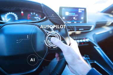 Otomatik pilot teknolojisini temsil eden fütüristik dijital grafiklerle otomatik sürüş modunu etkinleştirerek yapay zeka destekli araç kontrol düğmesine basan bir sürücünün yakın plan görüntüsü