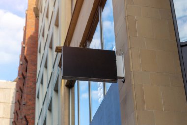 Üzerinde kuş çivileri olan siyah dikdörtgen mağaza tabelası, kentsel markalaşma modelleri, ticari tabelalar veya şirket reklamları için ideal.