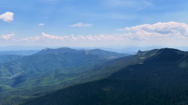 İnsansız hava aracı Jahorina 'nın uçsuz bucaksız orman sırtlarında süzülerek, açık mavi bir gökyüzü altında Bosna dağlarının katmanlarını yakalıyor.