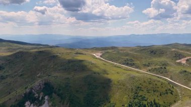 Jahorina yakınlarındaki yeşil tepeleri geçerken çekilen sinematik hava görüntüsü arazide ışık ve gölgeyi harmanlıyor.