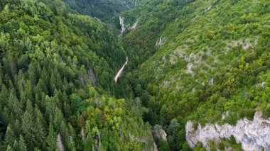 Dolambaçlı bir yolu ve orman yamaçları olan uzun kanyon geçidi, yumuşak sabah ışığında İHA 'lar tarafından yakalandı.