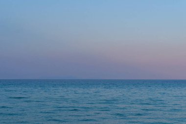 Açık deniz mavi alacakaranlık gökyüzünün altında belli belirsiz bir ufuk çizgisi