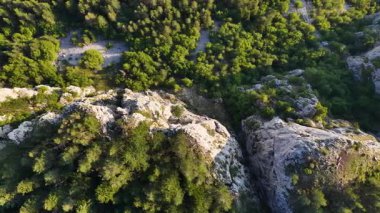 Dönek yol, dağın kalbinde saklanmış yeşilleri kesiyor.