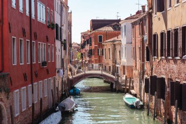 Küçük yaya köprüsü ve sakin sulara yansıyan eski evleri olan Venedik kanalını daralt