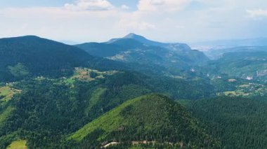 Trebevic Dağı 'nın yeşil orman yamaçları ve uzak ufku olan insansız hava aracı manzarası.