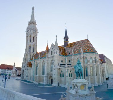 Macaristan 'ın Budapeşte kentindeki Trinity Meydanı' nda renkli kiremitli çatı ve binici heykeli ile Gotik Matthias Kilisesi manzarası