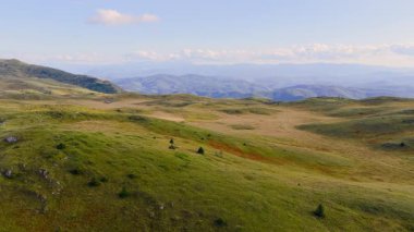 4K hava görüntüleri yumuşak dağ yamaçlarını, yeşil otlakları ve geniş dağlık arazi yaz manzaralarını gösteriyor..
