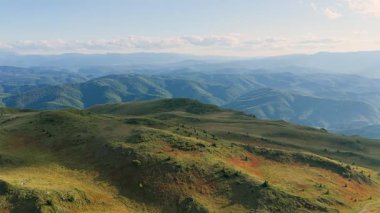 İnsansız hava aracı Bosna dağlarında yumuşak yaz ışığı altında alp yamaçlarını ve yeşil tepeleri yakalıyor.
