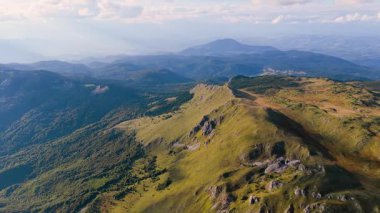 Alp sırtlarının üzerinden insansız hava aracı uçuşu. Yaz dağları boyunca görünür yürüyüş yolu var..
