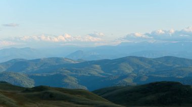 İnsansız hava aracı görüntüleri, yaz aylarında dağları aşan katmanlı tepeler ve geniş ufuklar gösteriyor.