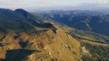 Açık yaz ışığında kaydedilen engebeli dağ tepeleri ve dik yamaçların görüntüleri.
