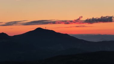 Trebevic tepesinin altın saatindeki insansız hava aracı görüntüleri. Parlak gökyüzü ve dağ silueti..