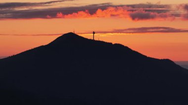 Gün batımında Trebevic 'in siluetinin görüntüsü görünür iletişim kulesiyle 4K drone görüntüsü..