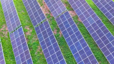 Kamera, yenilenebilir enerji teknolojisi, sürdürülebilir altyapı ve yeşil yatırımı gösteren hizalanmış fotovoltaik güneş panelleri üzerinde hareket ediyor.