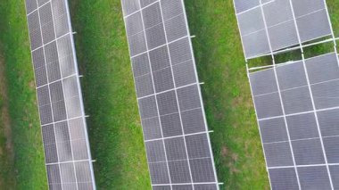 Dikey hava manzarası, yenilenebilir enerji teknolojisi ve sürdürülebilir altyapıyı gösteren hizalanmış satırlardaki güneş panellerini ortaya koyuyor.