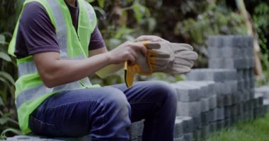 İnşaat alanına girmeden önce güvenlik eldiveni takan işçiler, güvenlik ve sanayi konsepti.
