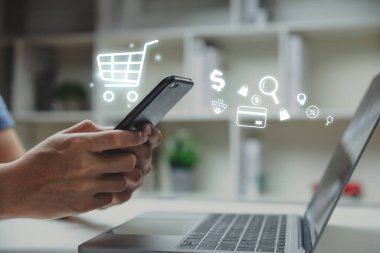 Young man using smartphone with shopping cart icon,  Online shopping and e-commerce concept.