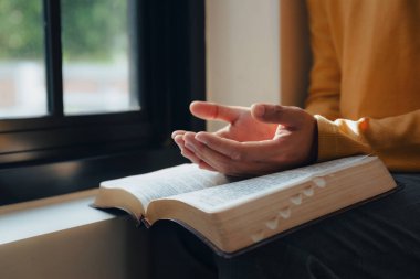 Bir adam kutsal incili katladı kütüphane ve kilisede, din ve ibadet kavramının penceresinin yanında.