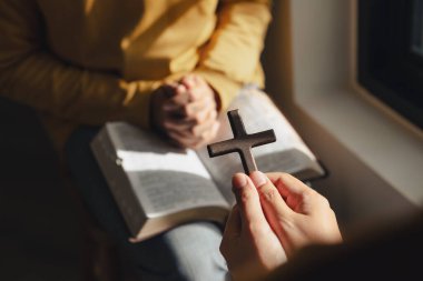 Kilisenin, dinin ve ibadetin penceresinde haç ve kutsal incili tutan bir adam..