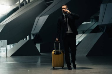 Endişeli iş adamı terminalde onun biniş kapısını, ulaşım istasyonundaki insanları bulmaya gidiyor.