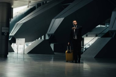 Endişeli iş adamı terminalde onun biniş kapısını, ulaşım istasyonundaki insanları bulmaya gidiyor.