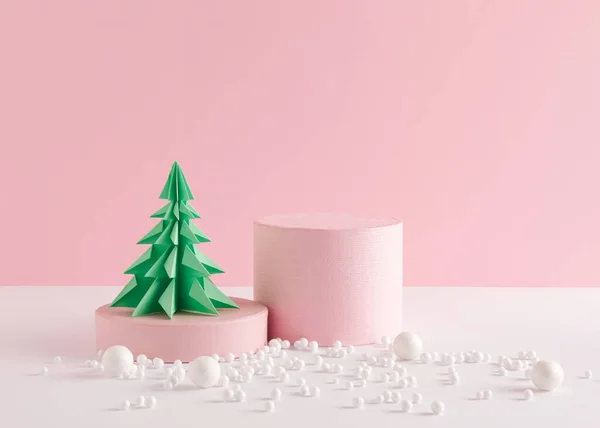 Origami Christmas tree with product podium and white Christmas baubles on pink background. Suitable for Product Display and Business Concept.