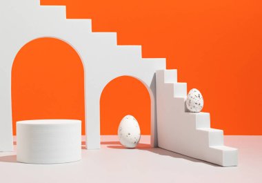 Podyum, ürün sunumu ve turuncu arka planda Paskalya yumurtaları. Marka ve festival ambalajı sunumu için bir model. Modern estetik.