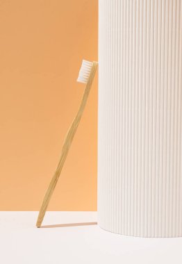 Turuncu arka planda çevre dostu bambu diş fırçası. Doğal organik banyo güzellik ürünü konsepti. Sağlık hizmetleri bileşimi.