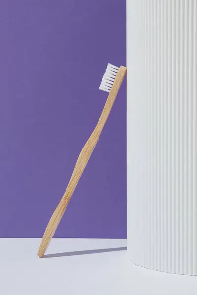 Mor arka planda çevre dostu bambu diş fırçası. Doğal organik banyo güzellik ürünü konsepti. Sağlık hizmetleri bileşimi.