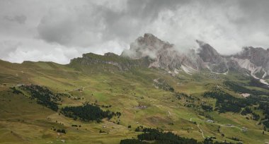 Val Gardena 'daki Dolomitler arasında geniş bir dağ vadisi manzarası
