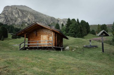 Dolomitler 'de bir dağ otlağının üzerinde harika manzaralı küçük bir ev.