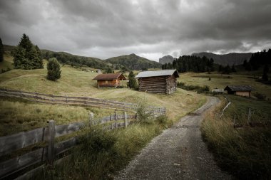 Dolomitler 'de bir dağ otlağının üzerinde harika manzaralı küçük bir ev.