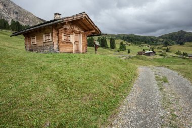 Dolomitler 'de bir dağ otlağının üzerinde harika manzaralı küçük bir ev.
