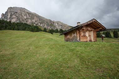 Dolomitler 'de bir dağ otlağının üzerinde harika manzaralı küçük bir ev.