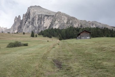 Dolomitler 'de bir dağ otlağının üzerinde harika manzaralı küçük bir ev.