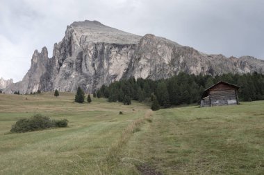 Dolomitler 'de bir dağ otlağının üzerinde harika manzaralı küçük bir ev.