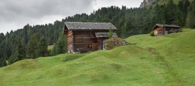 Dolomitler 'de bir dağ otlağının üzerinde harika manzaralı küçük bir ev.