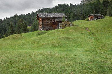 Dolomitler 'de bir dağ otlağının üzerinde harika manzaralı küçük bir ev.