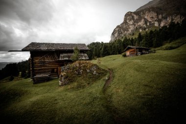 Dolomitler 'de bir dağ otlağının üzerinde harika manzaralı küçük bir ev.