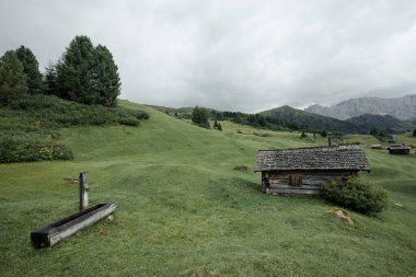 Dolomitler 'de bir dağ otlağının üzerinde harika manzaralı küçük bir ev.