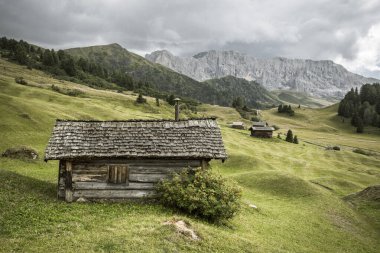 Dolomitler 'de bir dağ otlağının üzerinde harika manzaralı küçük bir ev.