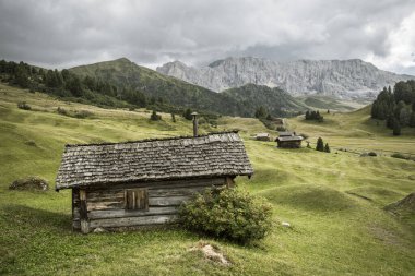 Dolomitler 'de bir dağ otlağının üzerinde harika manzaralı küçük bir ev.