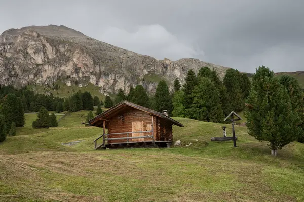 Dolomitler 'de bir dağ otlağının üzerinde harika manzaralı küçük bir ev.