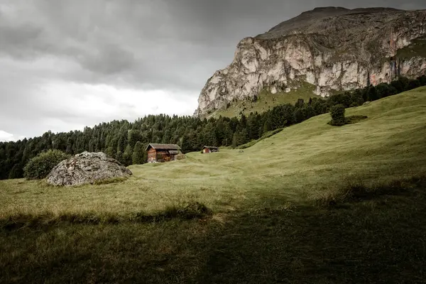 Dolomitler 'de bir dağ otlağının üzerinde harika manzaralı küçük bir ev.
