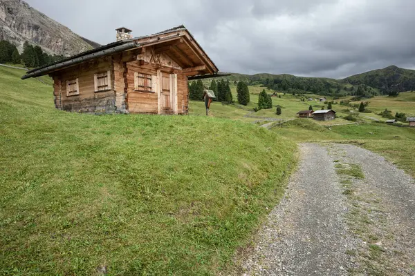 Dolomitler 'de bir dağ otlağının üzerinde harika manzaralı küçük bir ev.