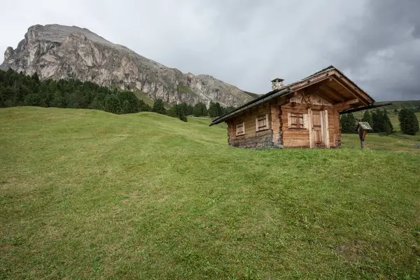 Dolomitler 'de bir dağ otlağının üzerinde harika manzaralı küçük bir ev.