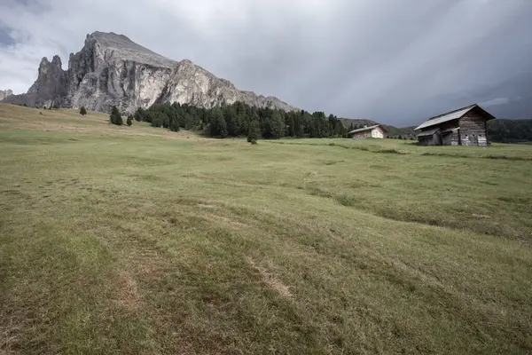 Dolomitler 'de bir dağ otlağının üzerinde harika manzaralı küçük bir ev.