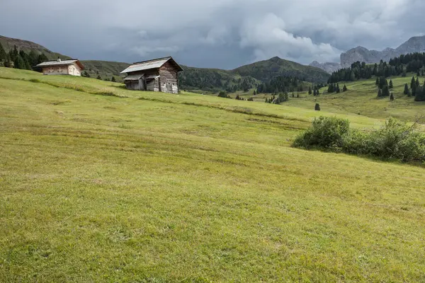 Dolomitler 'de bir dağ otlağının üzerinde harika manzaralı küçük bir ev.