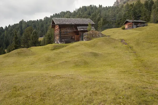 Dolomitler 'de bir dağ otlağının üzerinde harika manzaralı küçük bir ev.